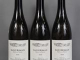 three bottles of wine sit on a table in front of a gray background