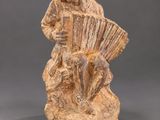 a statue of a man playing an accordion on a rock