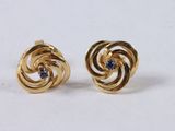 a close up of a pair of gold earrings with blue stones