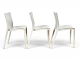 two white plastic chairs sitting next to each other on a white surface