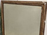 a large mirror with a gold frame and a white background