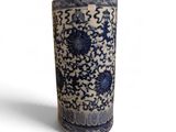 un vase bleu et blanc posé sur une surface blanche