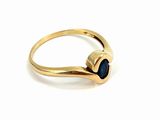 a close up of a gold ring with a black stone