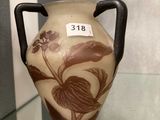 a vase on display in a glass case with a tag on it