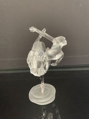 une figurine en verre représentant un oiseau et une fleur posée sur une table