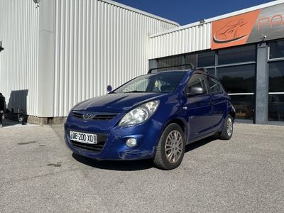 la voiture bleue est garée devant un bâtiment