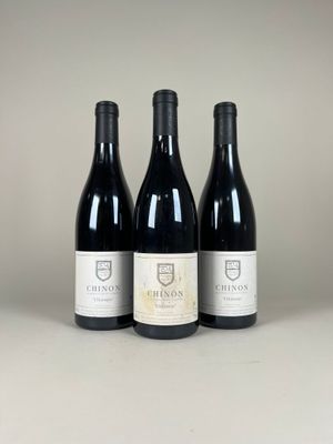 trois bouteilles de vin rouge posées sur une table