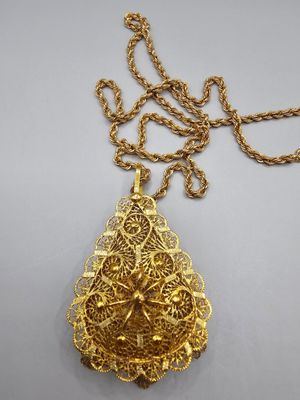 a gold plated necklace with a leaf pendant on a chain