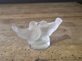 a glass bird sitting on top of a wooden table