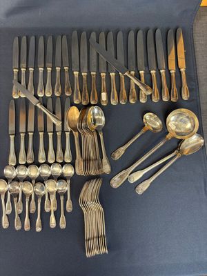 a lot of silver spoons and forks laid out on a table