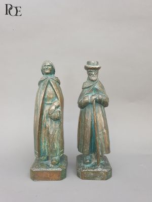 pair of bronze figurines of two men with hats and cloaks