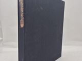 a black book sitting on top of a table next to a white wall