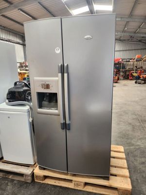 two refrigerators and a freezer in a warehouse