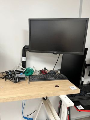 un bureau d'ordinateur sur lequel se trouvent un écran, un clavier et une souris