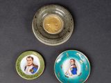 three small plates with pictures of people on them on a table