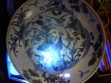 a blue and white plate with a picture of a woman on it