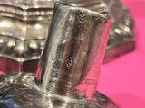 a silver candle that is on a pink table