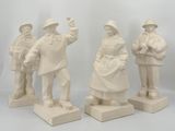 three white statues of men and women standing on a white surface