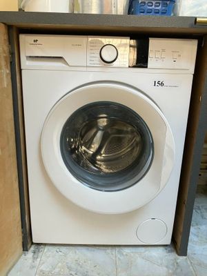 une machine à laver qui se trouve dans le coin d'une pièce