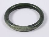 a close up of a green bracelet on a white surface