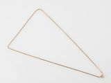 un collier en or avec un pendentif en forme de triangle sur fond blanc