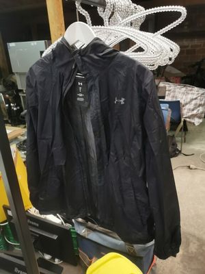 une veste noire suspendue à un portant dans un garage