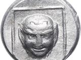 a close up of a silver coin with a face on it