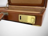 a brown suitcase with a key in it on a white surface