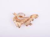 une image d'une broche en or et diamants sur fond blanc