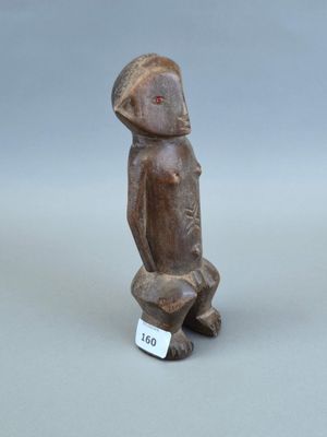 un gros plan sur une figurine représentant un oiseau, à laquelle est accrochée une étiquette