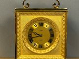 une horloge en or posée sur une table en bois