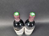 pair of two bottles of wine sitting on a black surface