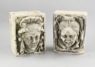 une paire de serre-livres en pierre sculptée représentant un visage de femme et une tête d'homme