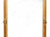an image of a gold framed mirror sitting on top of a white wall