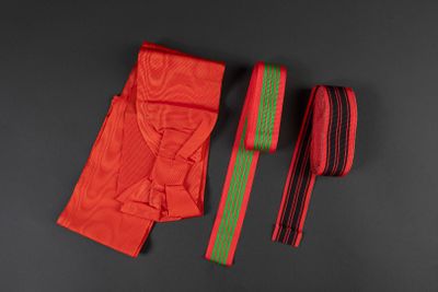 two red and green ties on a black surface