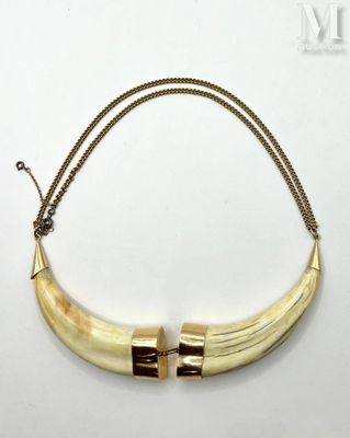 a close up of a necklace on a white surface with a chain