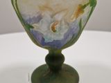 a glass vase with a flower on it on a table