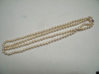 un gros plan d'un collier de perles blanches posé sur une table