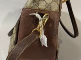 brown guccissi cross body bag with feather charm
