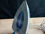 a blue and white iron sitting on a wooden table
