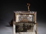 a small metal box that has a small figure on top of it