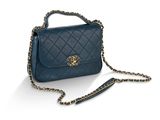 un sac à main bleu avec une bandoulière en chaîne sur fond blanc