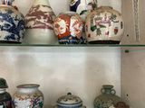 de nombreux vases et bols posés sur une étagère dans un meuble