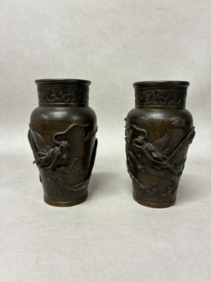 pair of bronze vases with birds on them on a white background