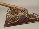 maquette en bois d'un canon posé sur un socle, sur fond blanc