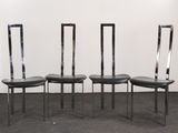 three black leather chairs sitting in a room with a white wall