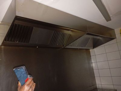 une personne tenant un téléphone portable à la main dans une cuisine