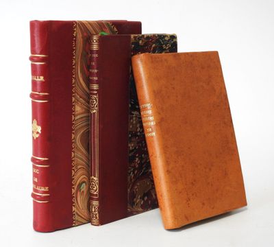 three books are stacked on top of each other on a white surface