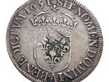 a close up of a silver coin with a crown on it