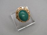 l'image d'une bague en or contenant une pierre verte